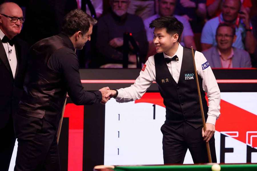 Ronnie O'Sullivan und Zhao Xintong geben sich vor dem Matchstart die Hand.