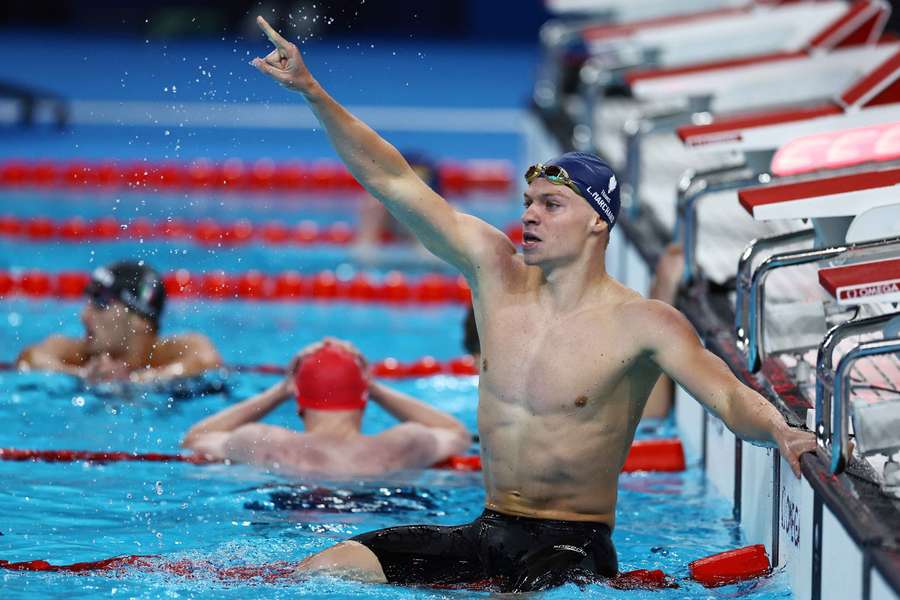 Leon Marchand salutes his home crowd after winning in the pool