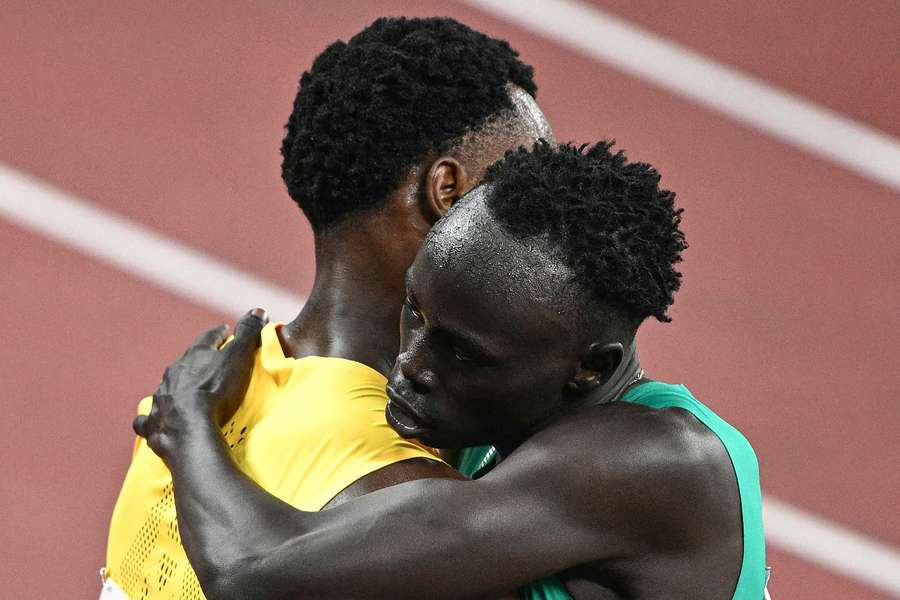 Gout Gout abraça o vencedor da eliminatória, Bryan Levell, da Jamaica 