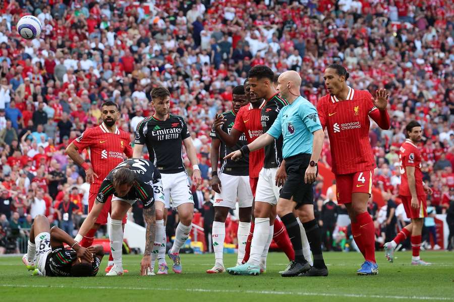 Players surround referee Anthony Taylor after Liverpool's Andrew Robertson sees his late goal disallowed for a foul on Myles Lewis-Skelly.