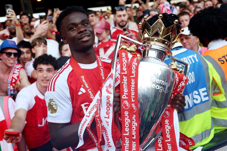 Arsenal's Bukayo Saka celebrates with the trophy after winning the Premier League Arsenal's Bukayo Saka celebrates with the trophy after winning the Premier League