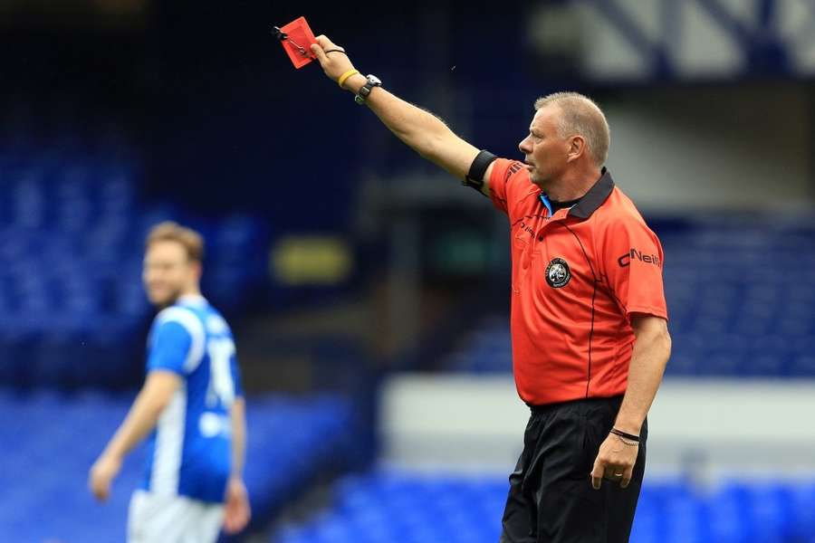 Former referee Mark Halsey gives a red card in a charity match