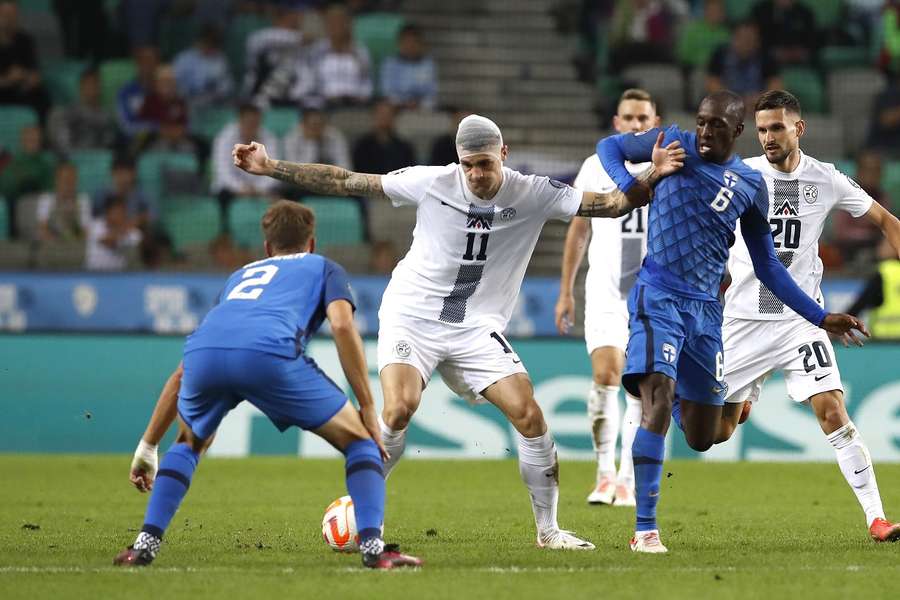 Erik Janza van Slovenia in duel met Leo Vaisanen en Glen Kamara van Finland