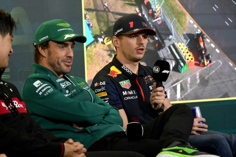 Red Bull Racing's Dutch driver Max Verstappen (R) speaks at a press conference