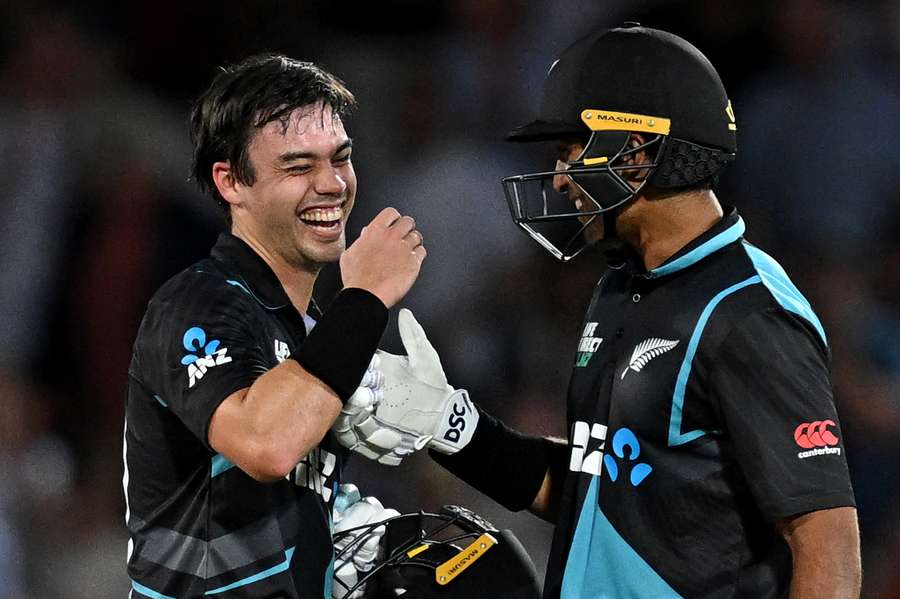 New Zealand's Mark Chapman (L) and New Zealand's Rachin Ravindra celebrate after winning the fourth T20 international cricket match