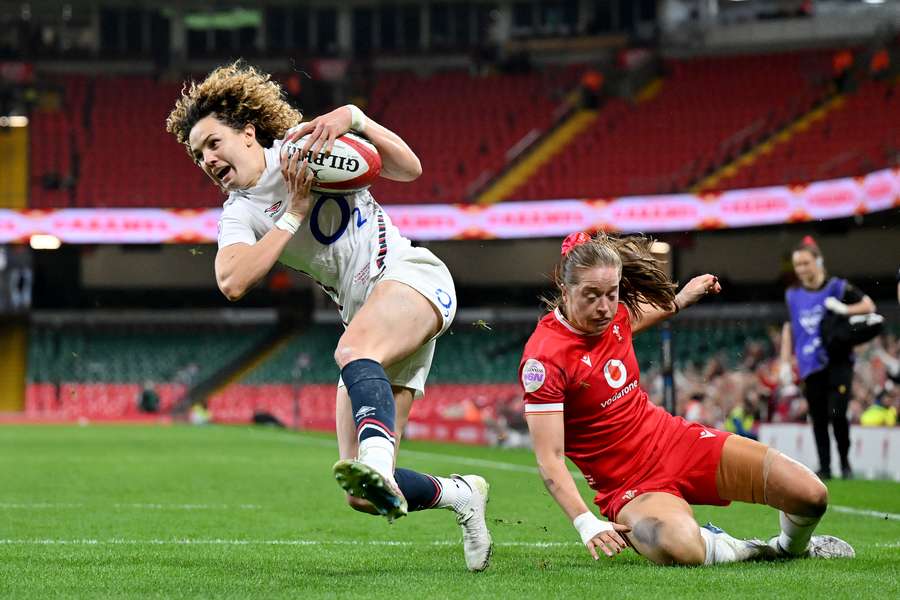 Ellie Kildunne of England breaks past Lisa Neumann of Wales as she runs in to score her team's fifth