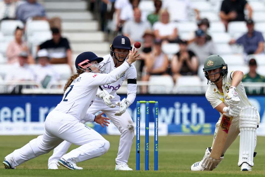 Australia's Ellyse Perry (R) plays a shot past England's Tammy Beaumont (L)