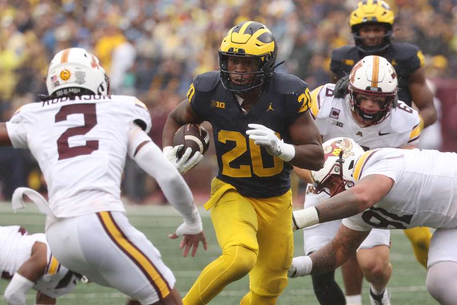 Michigan running back Kalel Mullings splitting Minnesota defenders