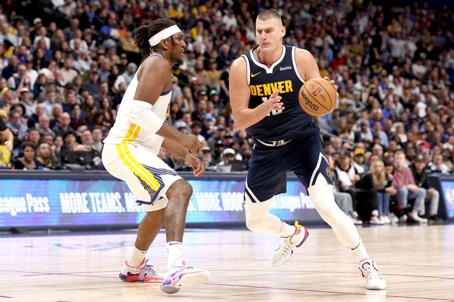 Nikola Jokic of the Denver Nuggets drives against Kevin Looney of the Golden State Warriors