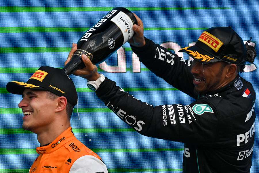 Second placed McLaren's British driver Lando Norris and third placed Mercedes' British driver Lewis Hamilton celebrate on the podium