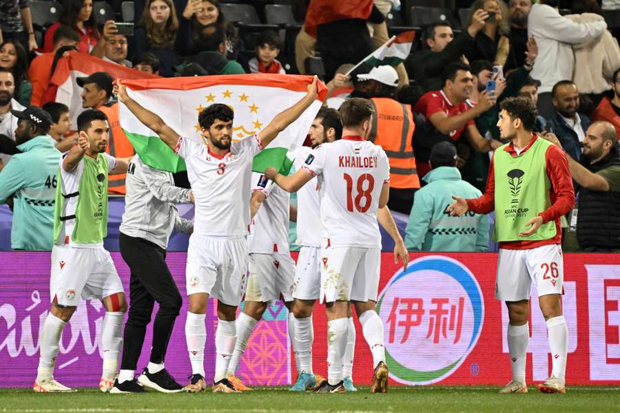 Tajikistan's players celebrate a historic win