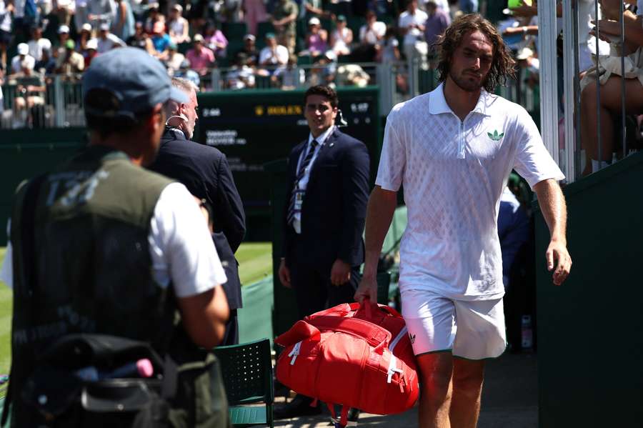 Stefanos Tsitsipas walks off court after being forced to retire