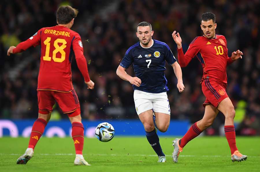 Scotland's midfielder John McGinn (C) vies with Spain's midfielder Mikel Oyarzabal (L) and midfielder Dani Ceballos