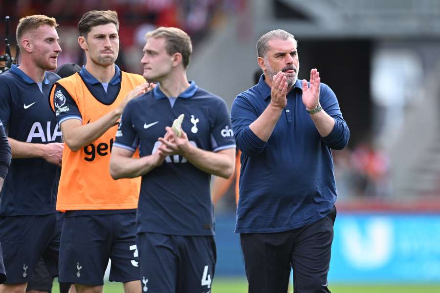 Tottenham Hotspur's Greek-Australian Head Coach Ange Postecoglou (R) and his players applaud fans after the match