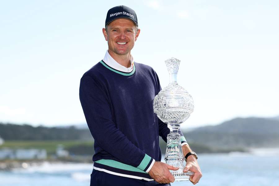 Justin Rose of England poses with the trophy on the 18th green 