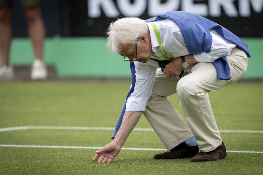 Een meneer voelt aan het gras