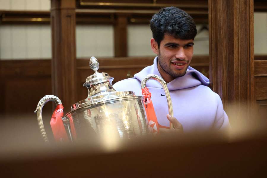 Alcaraz poses with his Queen's trophy in the locker room
