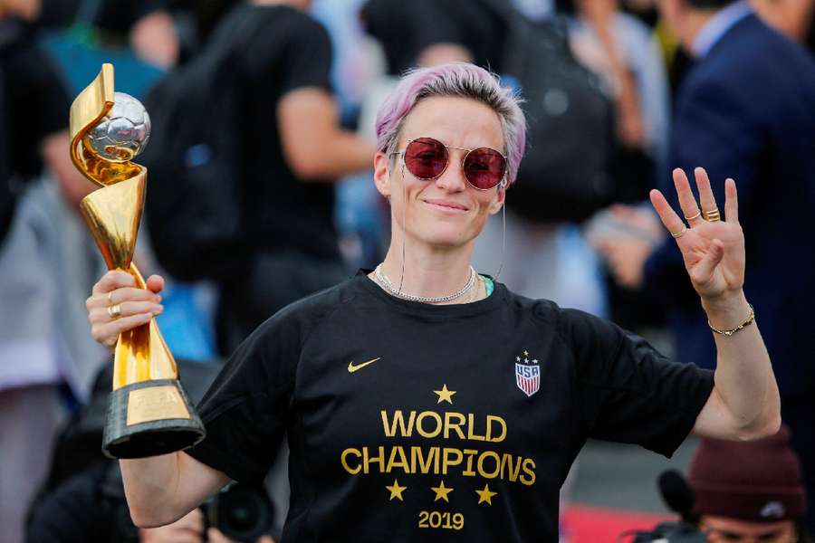 Megan Rapinoe gestures the number 4 with her fingers as she holds the Trophy for the FIFA Women's World Cup in 2019