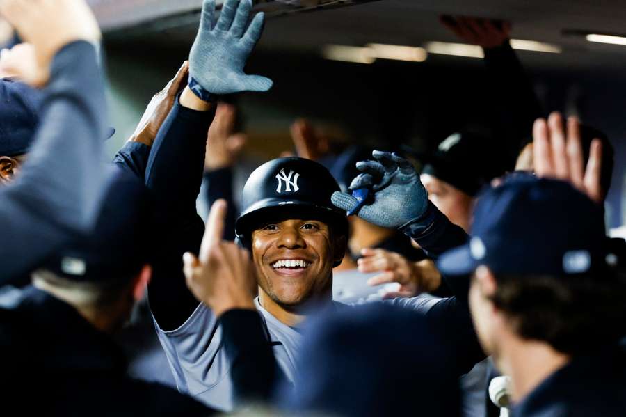 New York Yankees right fielder Juan Soto celebrates with teammates in the dugout after hitting a two-run home run against the Seattle Mariners