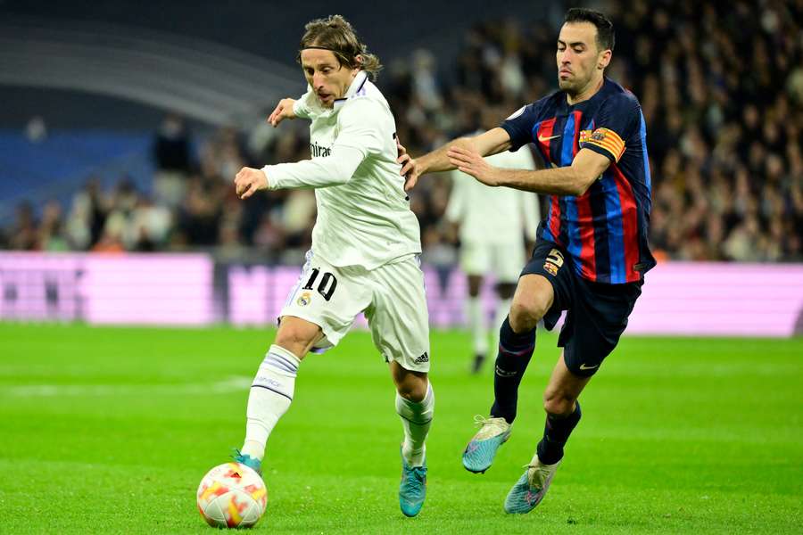 Luka Modric and Sergio Busquets battle for the ball at the Bernabeu
