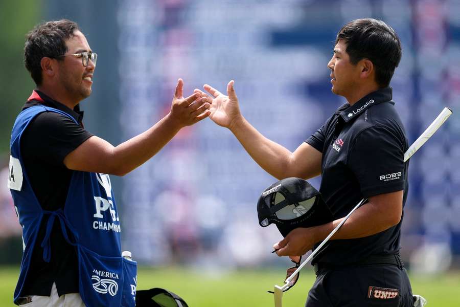Kurt Kitayama (R) shakes hands with his caddie