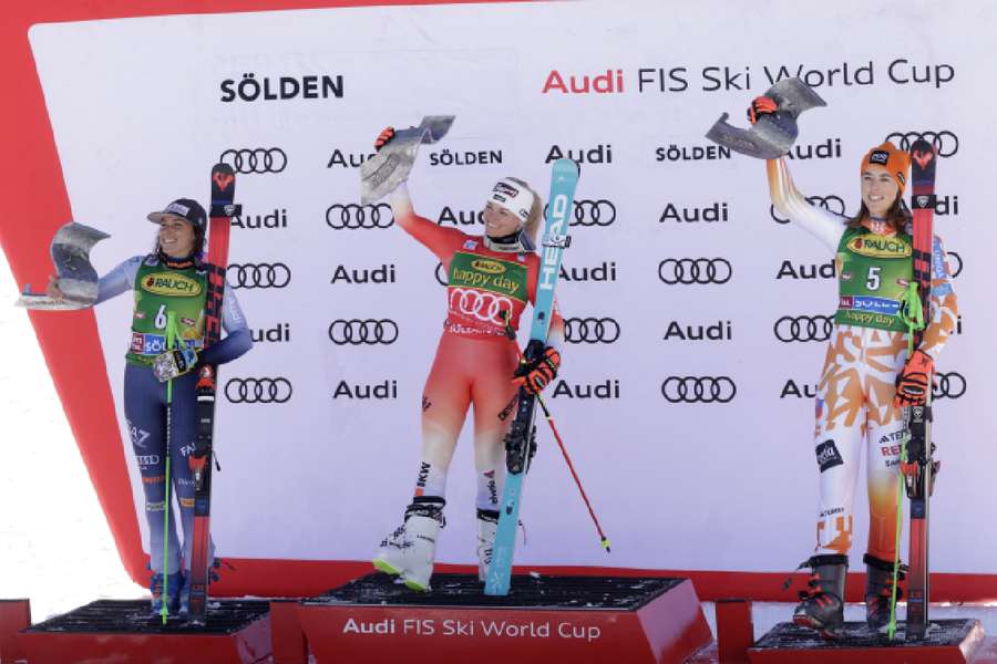 Gut-Behrami celebrates on the podium after winning the women's giant slalom with second-placed Brignone and third-placed Vlhova