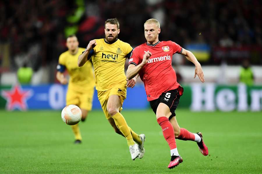 Union SG's Bart Nieuwkoop in duel met Leverkusen's Mitchel Bakker in de eerste wedstrijd