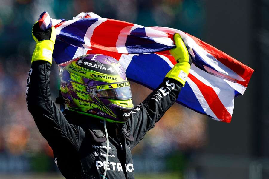 Lewis Hamilton waves the Union Flag above his head after the victory