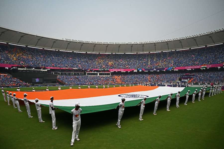 The Indian flag is held up in front of a packed out Narendra Modi Stadium