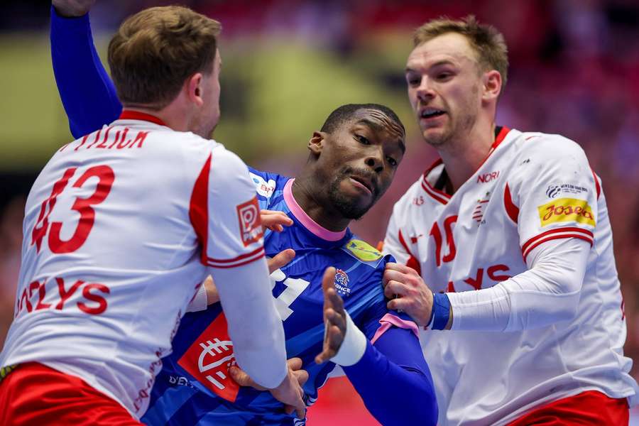 France's Dylan Nahi tries to break through Denmark's defense with Simon Pytlick and Mathias Gidsel