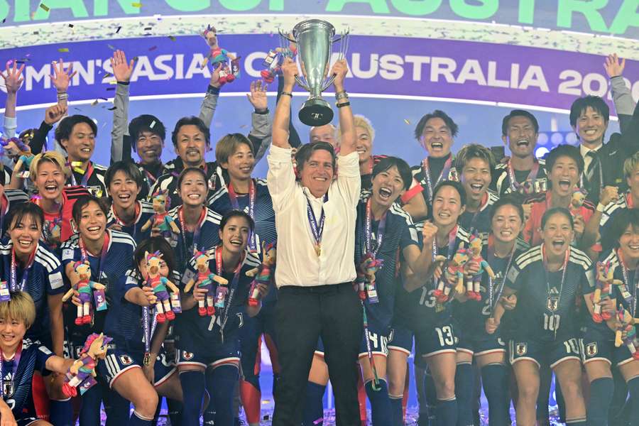 Japan coach Nils Nielsen lifts the Women's Asian Cup with his players. Japan coach Nils Nielsen lifts the Women's Asian Cup with his players.
