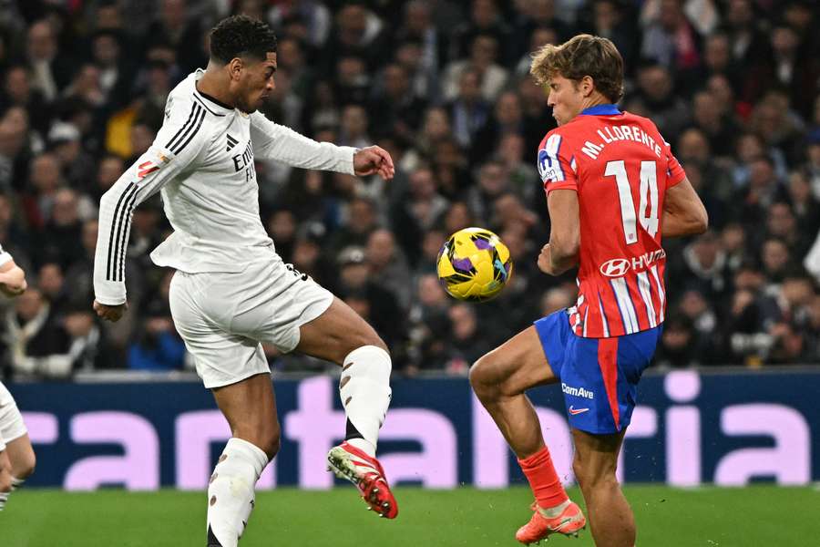 Jude Bellingham and Marcos Llorente battle for the ball