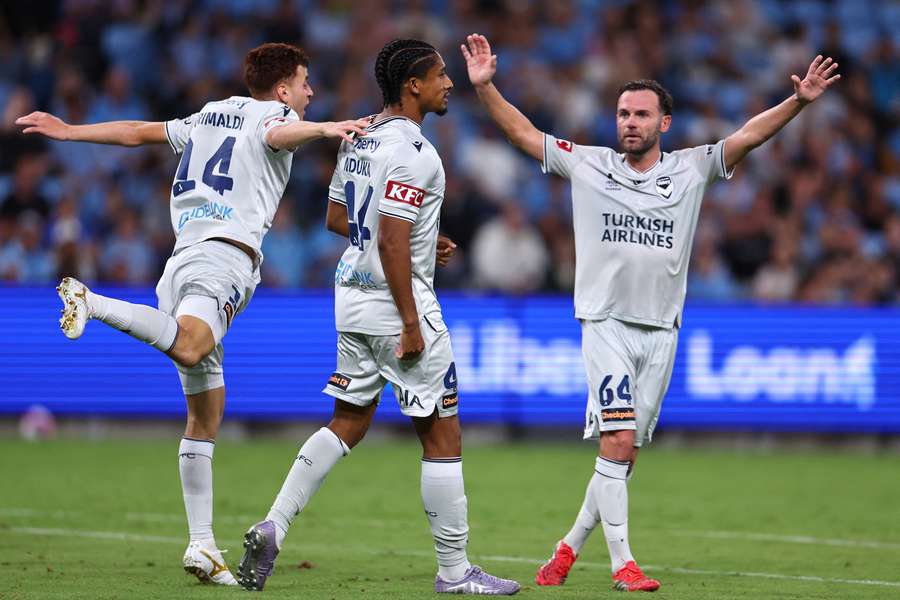 Matt Grimaldi, Charles Nduka and Juan Mata celebrate Melbourne Victory's second goal on Saturday.
