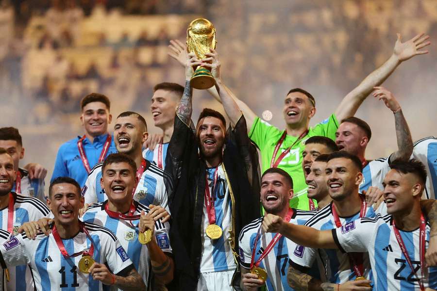 Lionel Messi, căpitanul Argentinei, ridică trofeul Cupei Mondiale alături de coechipierii săi, în timp ce aceștia sărbătoresc câștigarea turneului Lionel Messi, căpitanul Argentinei, ridică trofeul Cupei Mondiale alături de coechipierii săi, în timp ce aceștia sărbătoresc câștigarea turneului