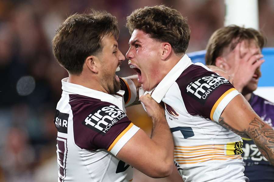 Reece Walsh (r) celebrates after scoring in the grand final