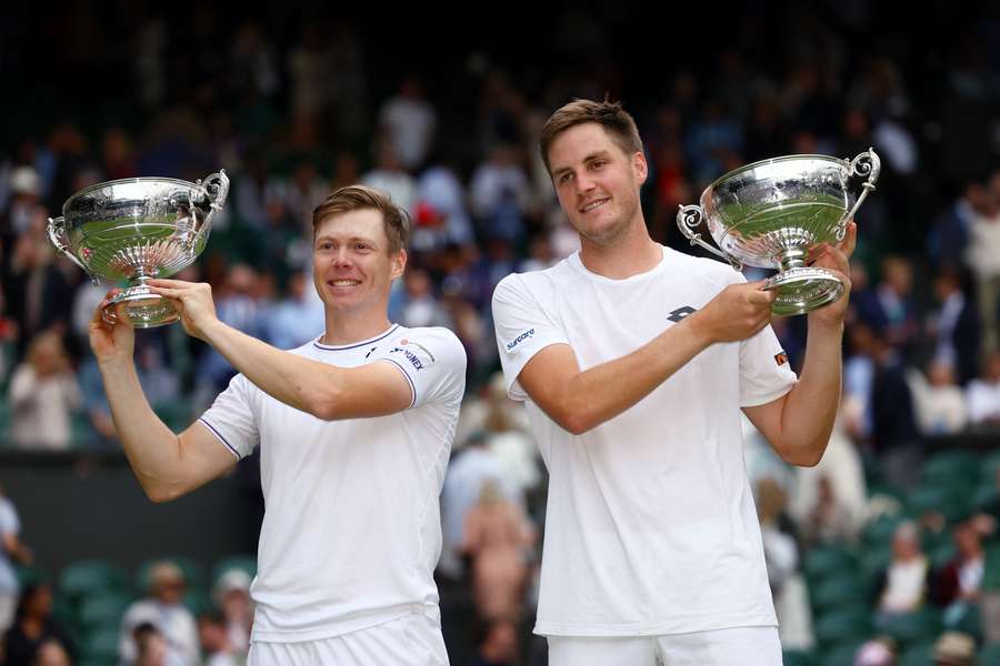 De ongeplaatste Henry Patten en Harri Heliovaara met hun prijzen voor het winnen van het dubbeltoernooi op Wimbledon