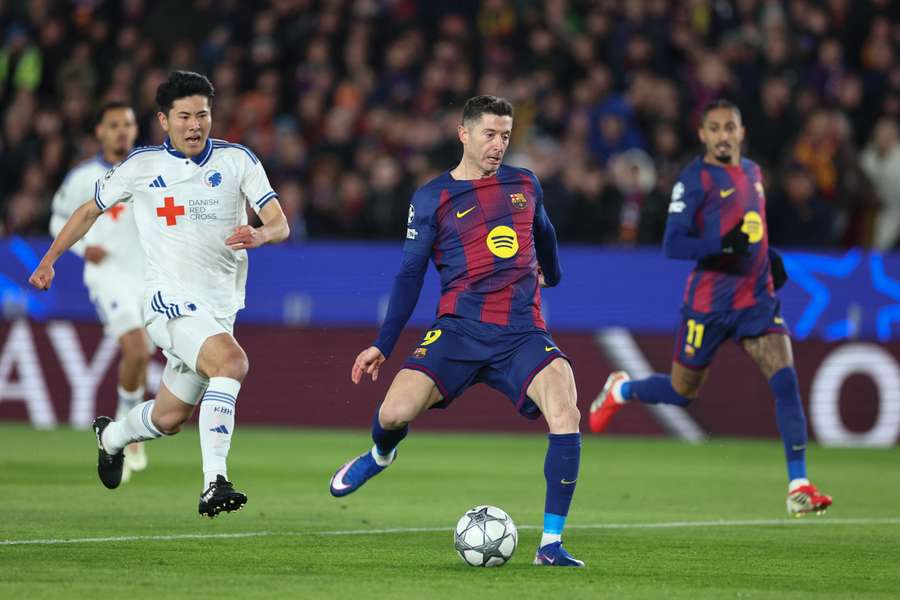 Robert Lewandowski frappe au but sous la pression de Junnosuke Suzuki lors du match de Ligue des champions entre le FC Barcelone et le FC Copenhague au Camp Nou, le 28 janvier 2026.