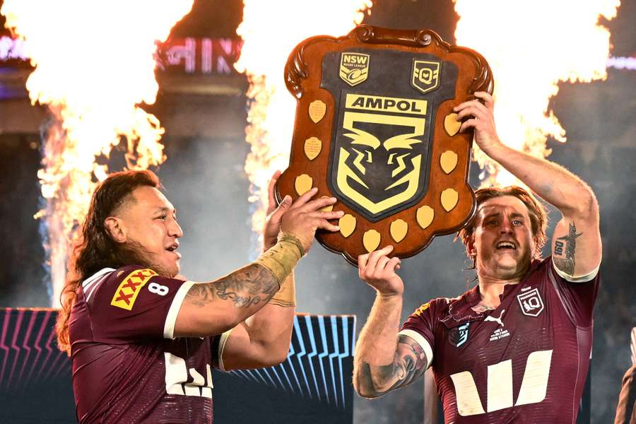 Maroons' Josh Papalii (left) and Cameron Munster lift the trophy after winning the State of Origin series
