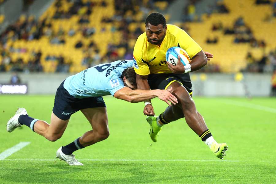Kini Naholo scores one of his three tries in the Hurricanes' Super Rugby Pacific win over the Waratahs.