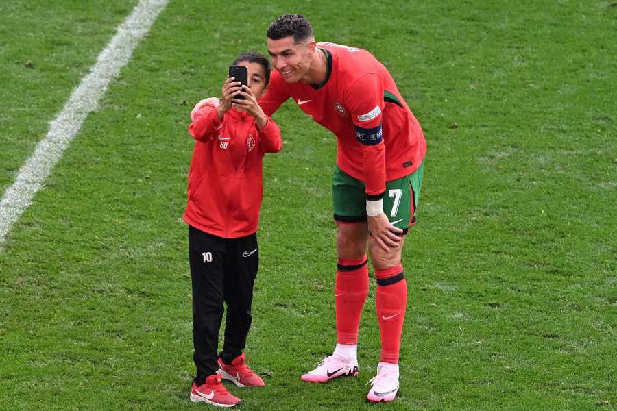 Ronaldo in posa per una foto con l'invasore di campo