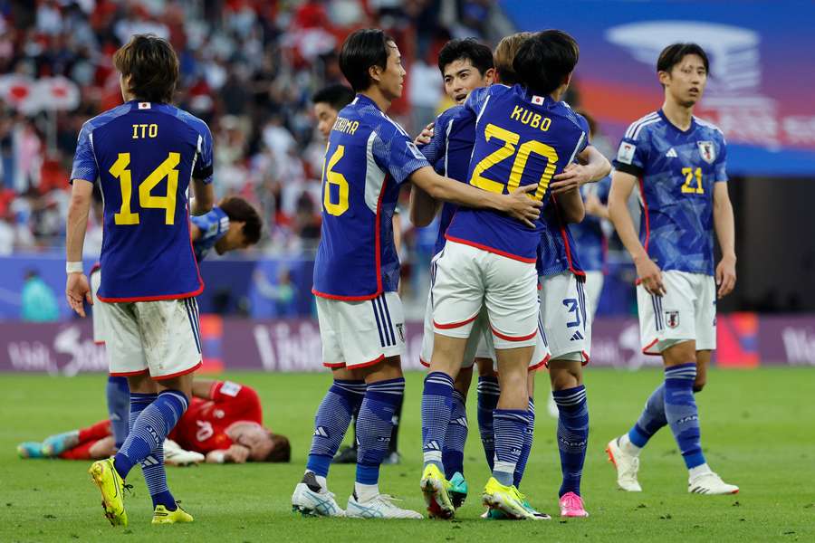 Japan's players celebrate their team's fourth goal 