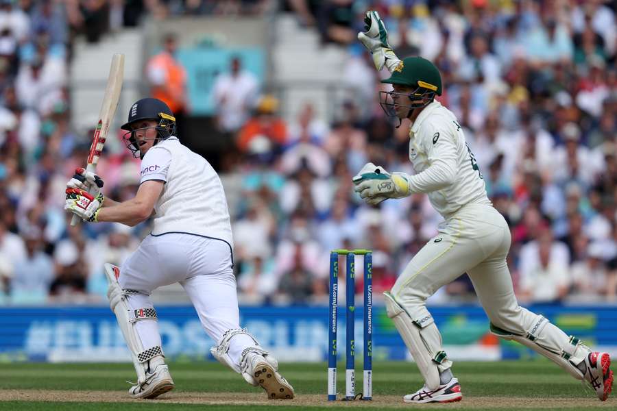 England's Zak Crawley (L) plays a shot as Australia's wicket keeper Alex Carey (R) keeps wicket