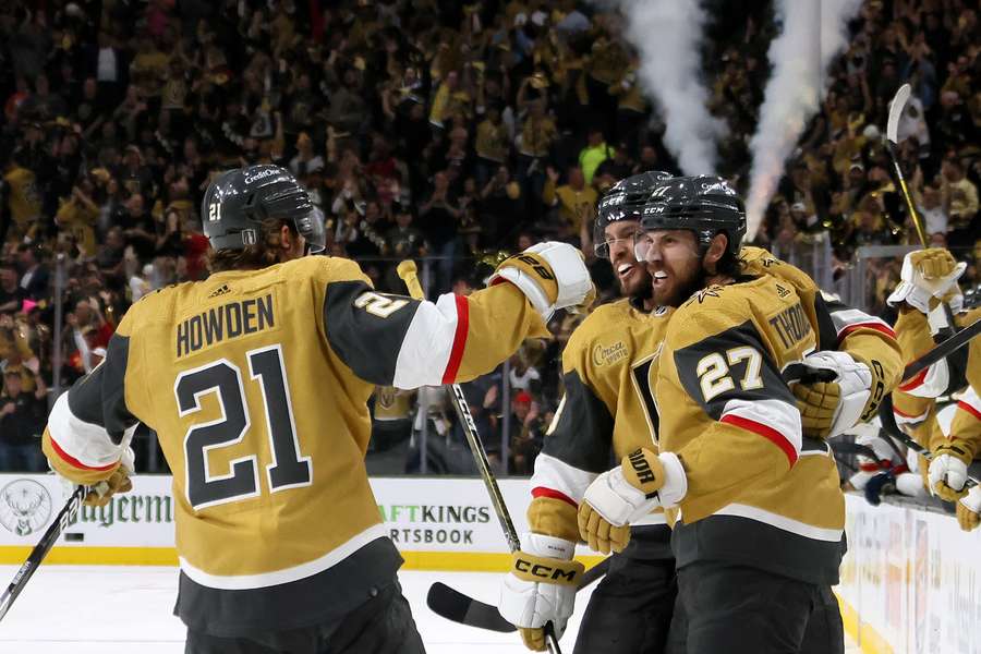 Shea Theodore #27 of the Vegas Golden Knights is congratulated by Brett Howden #21 and Brayden McNabb #3 after scoring a goal 