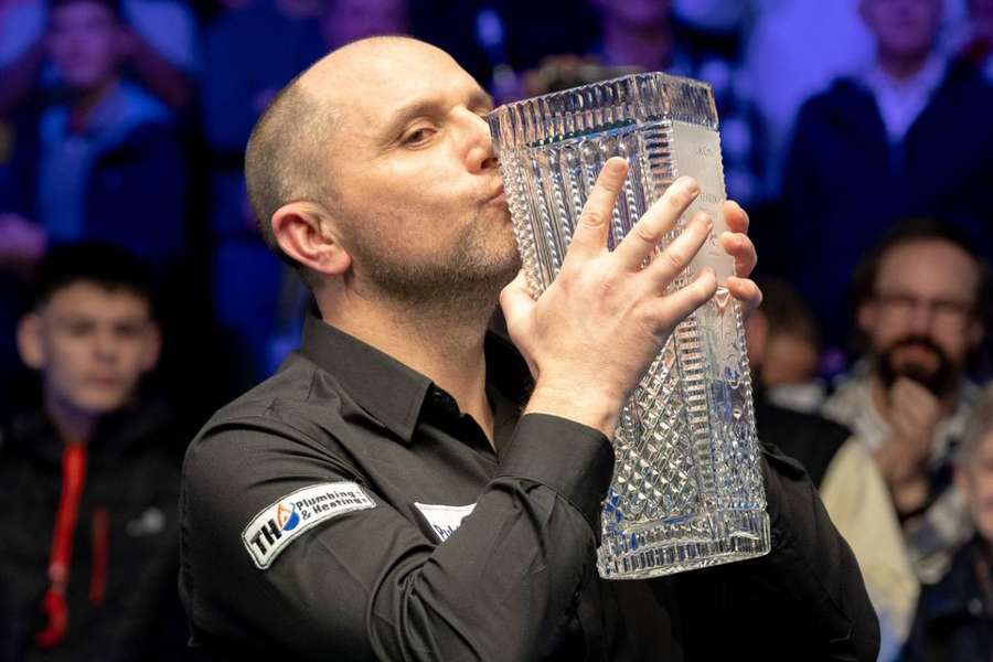 Joe Perry holds the Ray Reardon Trophy aloft after beating Judd Trump in the 2022 final