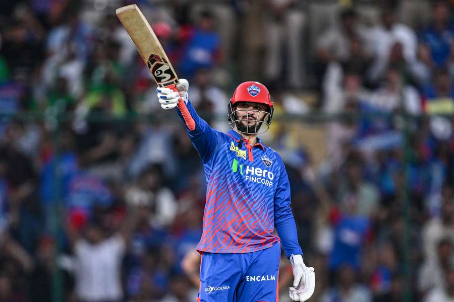 Sameer Rizvi raises his bat after reaching his half-century