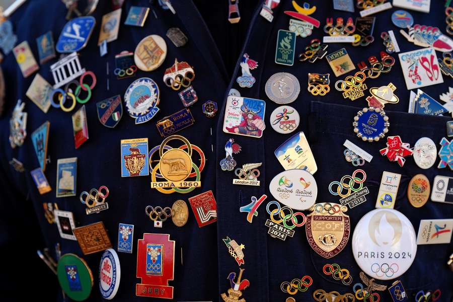 (Zdjęcie poglądowe) Kurtka jednego z kibiców pokryta olimpijskimi przypinkami przed ceremonią otwarcia na stadionie San Siro