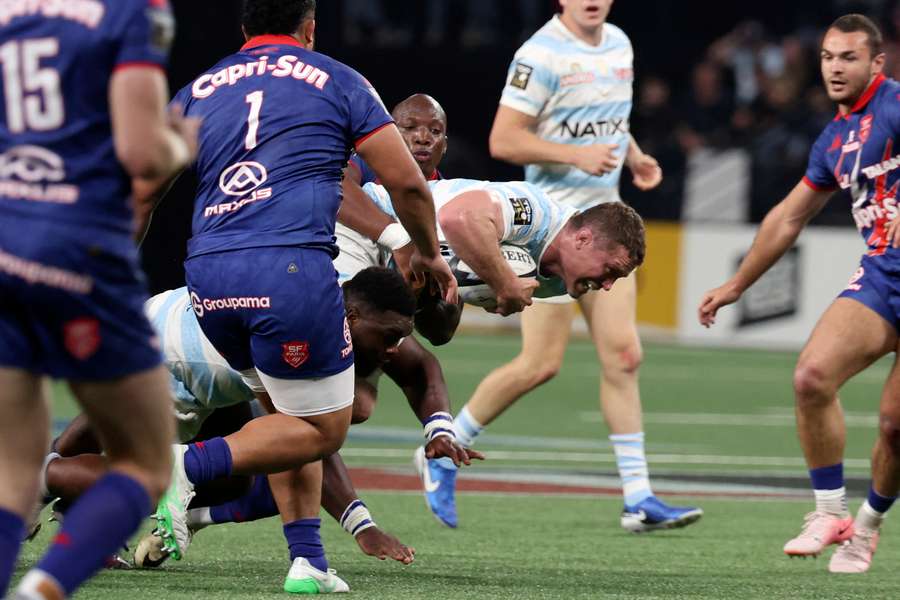 Racing 92's English lock Will Rowlands (c) is tackled during the Top14 match against Stade Francais