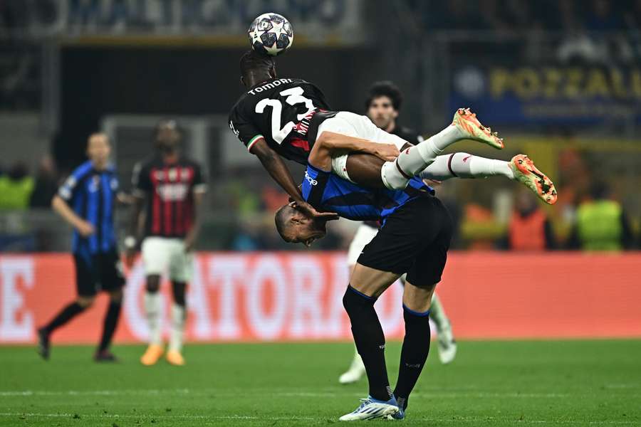 Fikayo Tomori leans on the back of Edin Dzeko