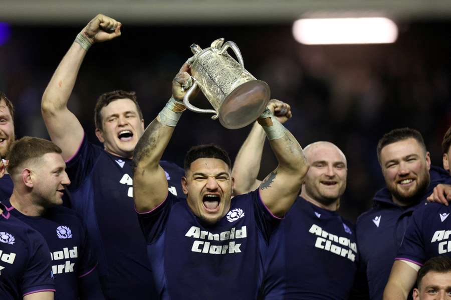 Scotland's Sione Tuipulotu lifts the Calcutta Cup trophy as he celebrates with teammates after victory over England