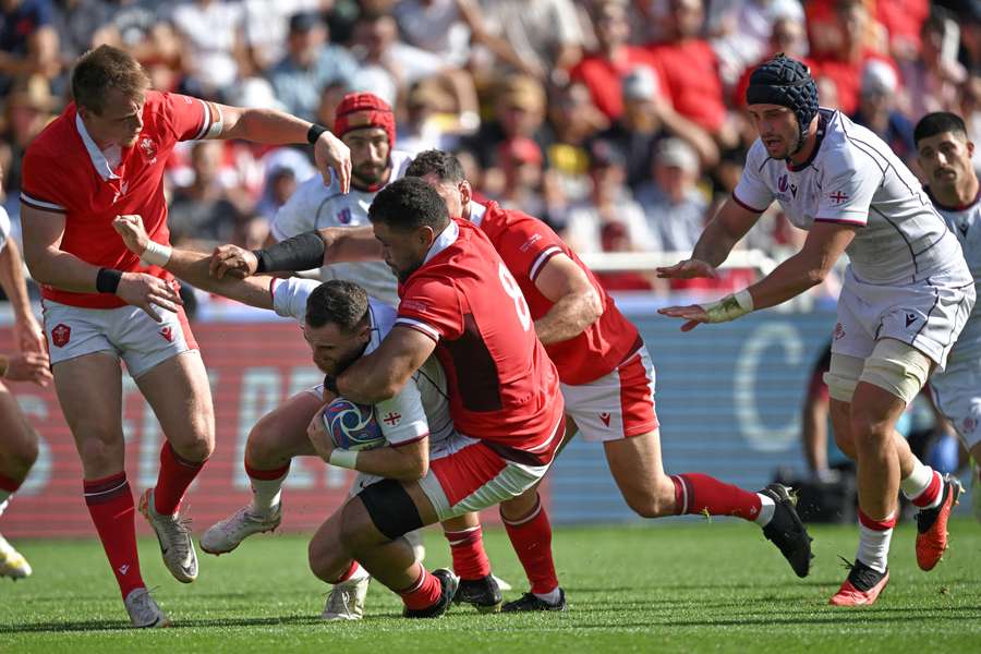 Georgia's scrum-half Vasil Lobzhanidze (C/L) is tackled by Wales' number eight Taulupe Faletau (C)